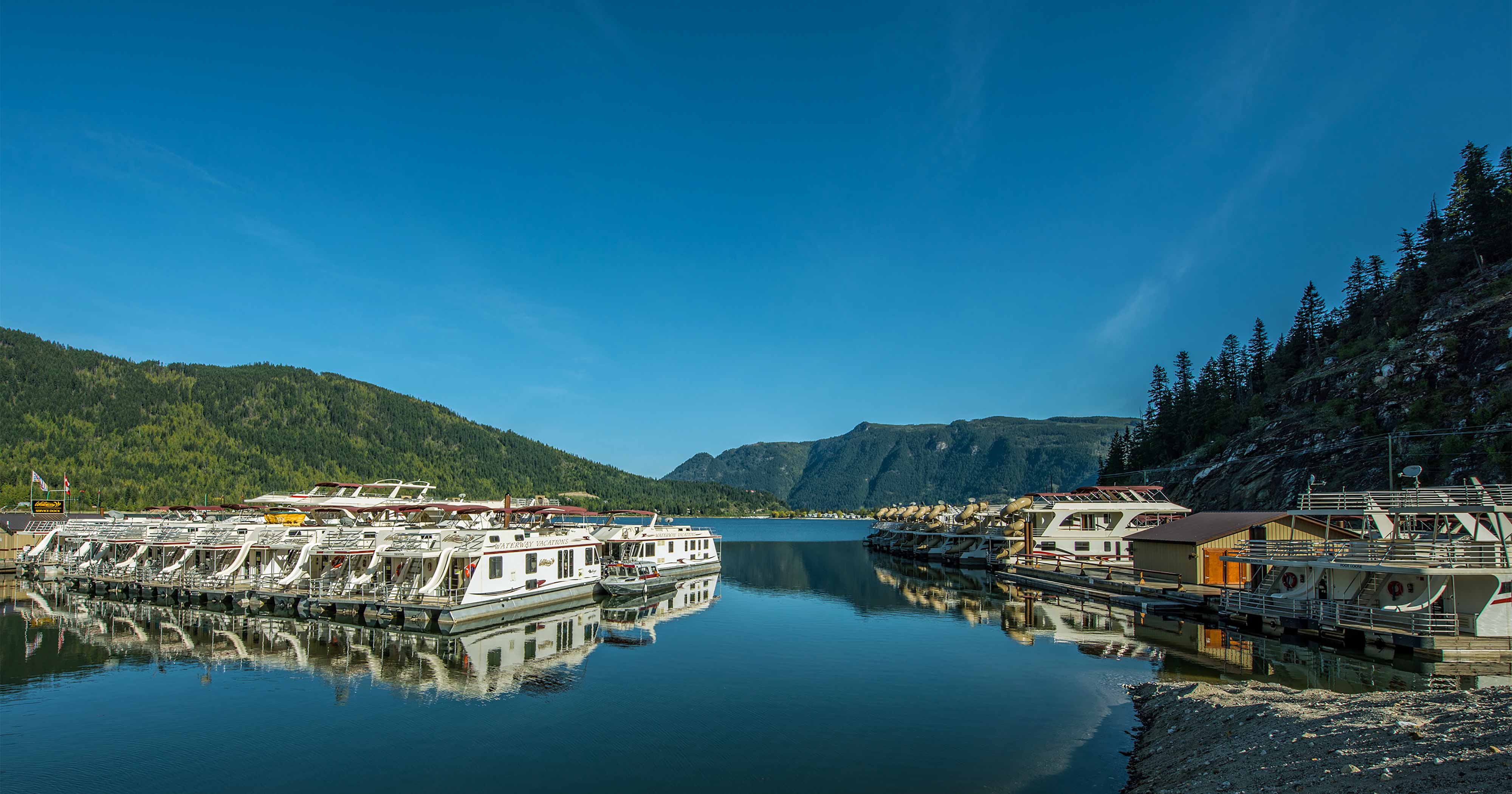 Sicamous Houseboats marina with houseboats docked in the spring time.